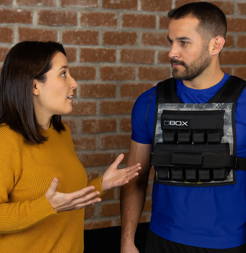 Woman asking question to a man wearing a weight vest